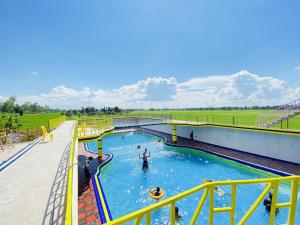 a swimming pool with people in the water at Chanchal Resort 