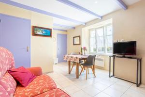 ein Wohnzimmer mit Sofa und Tisch in der Unterkunft Gite Glycine, Kerantum in Mahalon