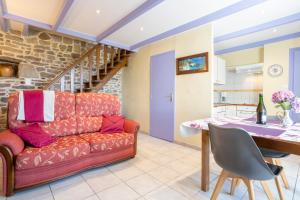 ein Wohnzimmer mit Sofa und Tisch in der Unterkunft Gite Glycine, Kerantum in Mahalon