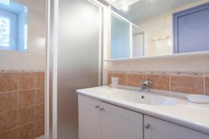 ein Badezimmer mit einem weißen Waschbecken und einer Dusche in der Unterkunft Gite Glycine, Kerantum in Mahalon + 18 Fotos