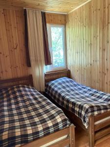 a bedroom with two beds and a window at Shatili ( Green House ) in Shatili