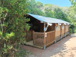 a building with a blue awning and a porch at CS Glamping - Tende in SantʼAnna