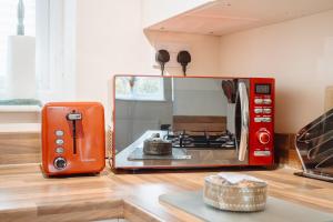 an orange toaster oven sitting on a kitchen counter at Spacious Holiday Home with Free Parking in Harrogate
