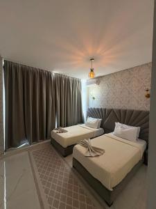 two beds in a hotel room with curtains at Hotel Golden Star in Taounate +53 photos