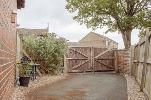 a driveway with a wooden gate in front of a house at Spacious Holiday Home with Free Parking in Harrogate