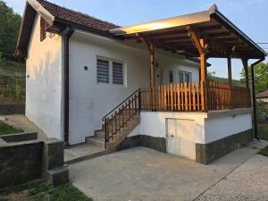 a house with a porch with a wooden deck at Seosko domaćinstvo Trajković 