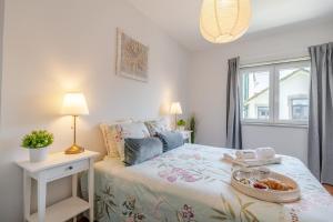 a bedroom with a bed with a tray of food on it at HostWise - Bright & Spacious Flat w/ Garage in Porto