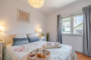 a bedroom with a bed with a tray of food on it at HostWise - Bright & Spacious Flat w/ Garage in Porto +42 photos