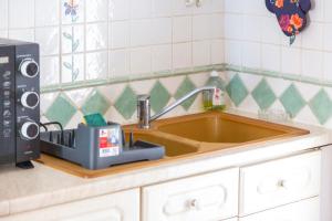 a kitchen counter with a sink and a microwave at Gîte Ty Bihan in Rosporden +15 photos