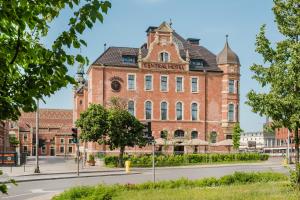 a large red brick building with a sign on it at Craft Beer Central Hotel in Gdańsk