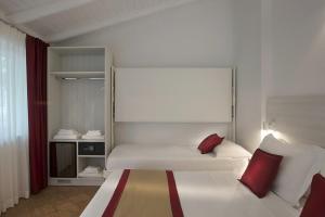 a bedroom with a large white bed with red pillows at Primavilla Relais in Gaeta