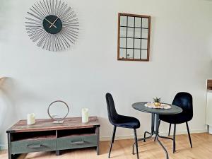 comedor con mesa, 2 sillas y reloj en Apt. and garage : Train station, Univ, en Villeurbanne