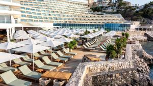 a row of lounge chairs and umbrellas at a hotel at Rixos Premium Dubrovnik in Dubrovnik