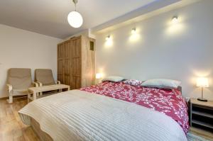 1 dormitorio con 1 cama grande y 1 silla en Apartament Brzeźno, en Gdansk