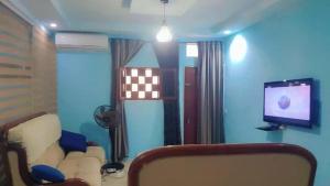 un soggiorno con un divano e una TV di Résidence SKS Hébergement a Dakar Altre 3 foto