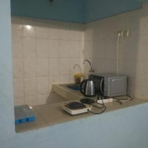 un bancone cucina con tostapane e forno a microonde di Résidence SKS Hébergement a Dakar