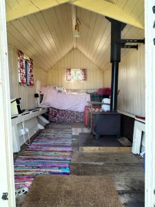 a small room with a bed and a rug at The Shepherds Hut in Hindringham