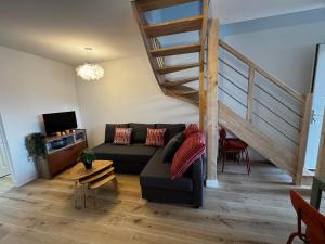a living room with a couch and a staircase at Maison pilotis 6 pers 50m mer in Les Moutiers