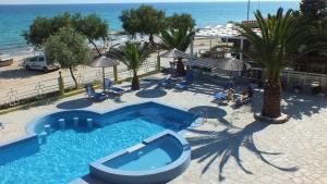 einen Blick über einen Pool neben einem Strand in der Unterkunft Boutique Giannikis By The Beach in Limenaria