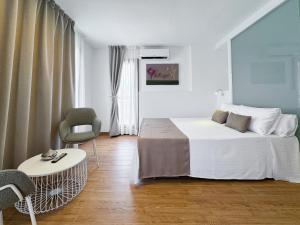 a bedroom with a bed and a table and a chair at Emerald Sun Hotel in Cambrils
