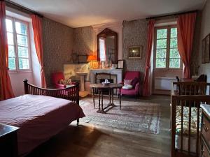 a bedroom with a bed and a table and a fireplace at Villa historique à Berrias-et-Casteljau, 350 m² avec piscine privée in Berrias Et Casteljau