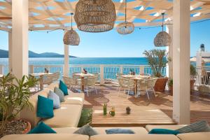 a patio with tables and chairs and a view of the ocean at The Chedi Luštica Bay in Tivat