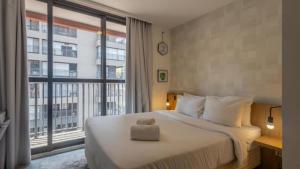 Un dormitorio con una cama y una ventana grande. en 360 Vila Mariana, en São Paulo