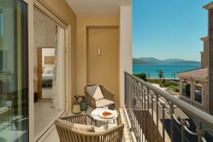 a balcony with a table and chairs and a view of the ocean at The Chedi Luštica Bay in Tivat