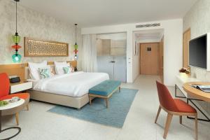 a hotel room with a bed and a table and chairs at The Chedi Luštica Bay in Tivat