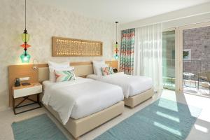 a hotel room with two beds and a balcony at The Chedi Luštica Bay in Tivat