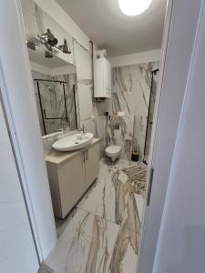 a bathroom with marble walls and a sink at PRZENOCUJ - Namysłów in Namysłów