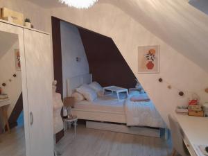 Schlafzimmer mit einem Bett mit einem großen Kopfteil aus Holz in der Unterkunft Chez Delphine et Bob -Ancienne Maison de Tanneurs in La Suze-sur-Sarthe