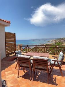 a patio with a table and chairs and the ocean at B&B Les Capitaineries in Bonifacio