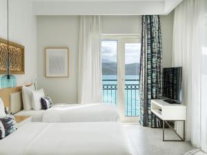a hotel room with two beds and a window at The Chedi Luštica Bay in Tivat