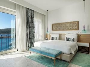 a bedroom with a large bed and a large window at The Chedi Luštica Bay in Tivat