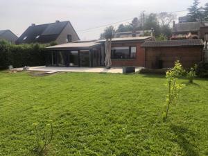 a house with a green yard with a house at Le Coeur sur la Main in Namur +7 photos