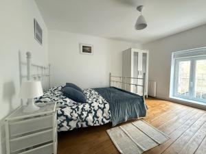 エルマンヴィル・シュル・メールにあるMaison de charme sur la côteのベッドとドレッサーと窓のある寝室