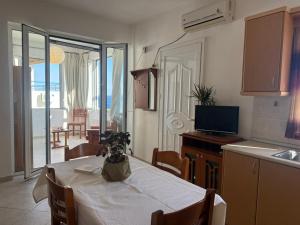 a kitchen with a table with a white table cloth on it at LEFKADA TWINS 2 in Agios Kirykos