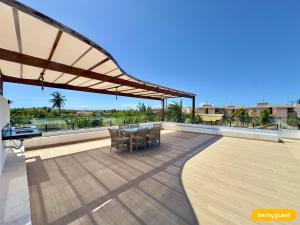 a patio with a table and chairs on a roof at Bella Arte 2 Rooftop in Aquiraz