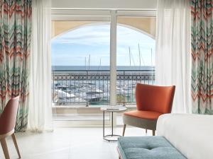 a living room with a large window with a view of the ocean at The Chedi Luštica Bay in Tivat