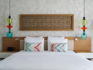 a bedroom with a white bed with two pillows at The Chedi Luštica Bay in Tivat