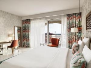 a hotel room with a large bed and a desk at The Chedi Luštica Bay in Tivat