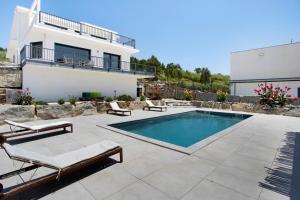 a patio with a swimming pool and a house at Peace House Lourinhã in Lourinhã