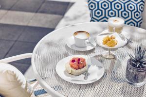 a table with two plates of food and a cup of coffee at Hotel Atlantic Hamburg, Autograph Collection in Hamburg