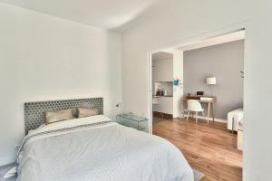 a white bedroom with a bed and a mirror at Spacieux et lumineux appartement in Paris +7 photos