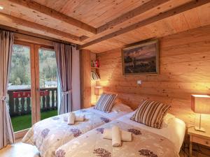 sypialnia z dwoma łóżkami w chacie z bali w obiekcie Charmant appartement près pistes et centre, WiFi, parking privatif - FR-1-343-193 w Chamonix-Mont-Blanc