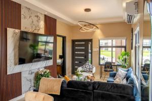 un salon avec un canapé et une télévision dans l'établissement The Luxe Escape Luxury Suite, à Stanmore Grove