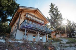 a log house with a balcony on the side of it at Feriendorf Koralpe Chalet Alpenperle in Hartelsberg