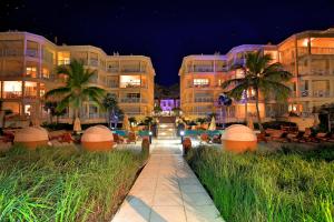 a walkway in front of a building at night at Windsong on the Reef in Grace Bay