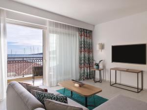 a living room with a couch and a flat screen tv at The Chedi Luštica Bay in Tivat